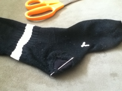 Step 5: Turn sock right-side out, put the sock on your hand again, and do another round of running stitches to further secure the patch.